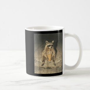 Lustiger Waschbär trinkt eisgekühlten Kaffee unkon Kaffeetasse