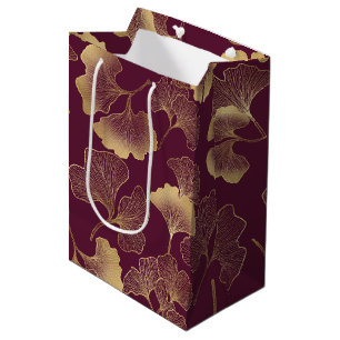 Luxuriöse goldene Ginkgoblätter auf tiefem Burgund Mittlere Geschenktüte