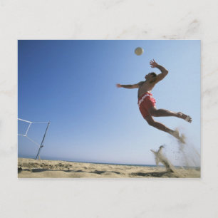 Male beach volleyball player jumping up to spike postkarte