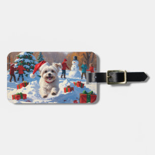 Malteserhund läuft im Schnee mit Weihnachtsmütze Gepäckanhänger