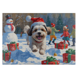 Malti Tzu läuft im Schnee mit Weihnachtshut Schneidebrett