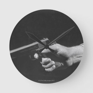 Man Holding Gun Runde Wanduhr