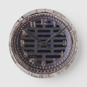 Manhole cover and cobblestone road clock runde wanduhr