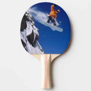Mann auf einem Snowboard, der von einem Gesims spr Tischtennis Schläger