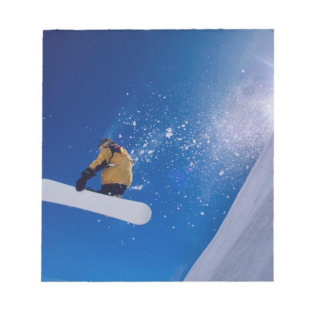 Mann, der auf einem Snowboard durch die Luft flieg Notizblock (Vorderseite)