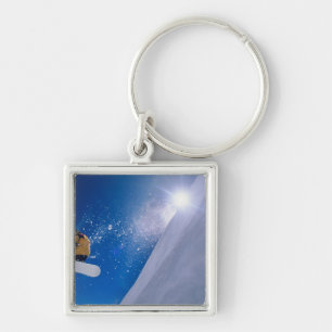 Mann, der mit einem Snowboard durch die Luft flieg Schlüsselanhänger