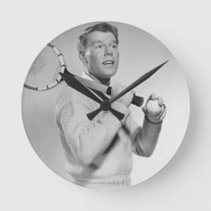 Mann, der Tennis-Schläger hält Runde Wanduhr