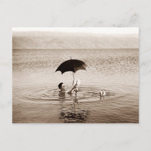 Mann, der unter einem Regenschirm im Toten Meer li Postkarte