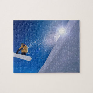 Mann fliegt auf einem Snowboard durch die Luft mit Puzzle