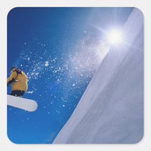 Mann fliegt auf einem Snowboard durch die Luft mit Quadratischer Aufkleber