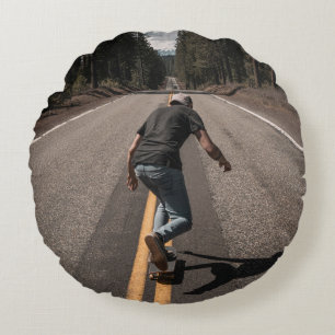 Mann spielt morgens Skateboard auf der Straße Rundes Kissen
