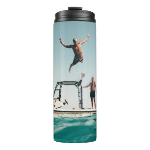 Mann taucht im Pool Thermosbecher