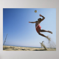 Männlicher Beachvolleyball-Spieler springt hoch un