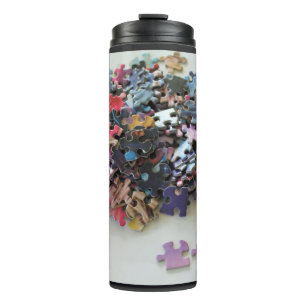 Mehrfarbige Puzzleteile auf einem Wärmespeicher Thermosbecher