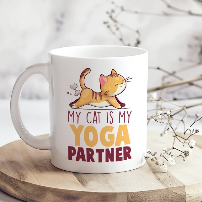 "Meine Katze ist mein Yogapartner" Funny Kaffeetasse ("My Cat is My Yoga Partner" Funny Coffee Mug on a boho kitchen table with tiny white flowers)