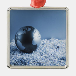 Metallkugel auf zerrissenem Papier Silbernes Ornament