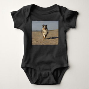 Miniatur-American-Shepherd läuft am Strand Baby Strampler
