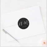 Minimale Schwarz-weiße Mongram Script-Hochzeit Runder Aufkleber<br><div class="desc">Erhöhen Sie Ihre Hochzeitdetails mit dem Minimalistischen Monogram Script Custom Wedding Date Sticker. Dieser elegante und personalisierte Aufkleber fügt Ihrem Hochzeitsgeschenk eine Touch von Eleganz hinzu, sodass Sie Ihr Mono- und Hochzeitsdatum auf einfache, aber wirkungsvolle Weise präsentieren können. Weiße Typografie-Skript auf schwarz. Der Aufkleber zeichnet sich durch ein minimalistisches Skriptdesign...</div>