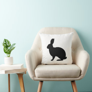Minimalistische schwarze Hasensilhouette auf weiße Kissen