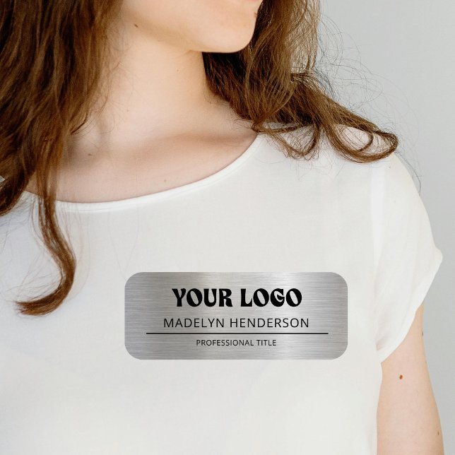 Mitarbeiter mit Metallsilber-Firmenlogo Namensschild (Von Creator hochgeladen)