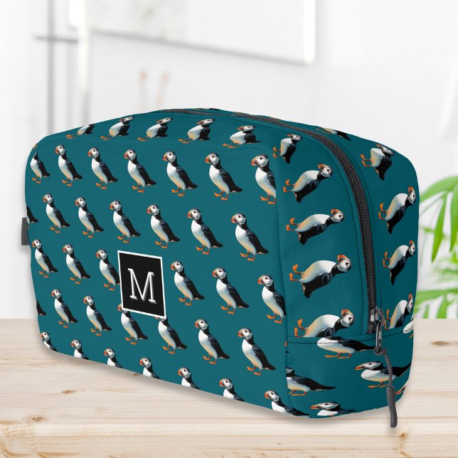 Monogramm zur Artenvielfalt an der Vogelküste Waschbeutel (A monogrammed toiletry bag in dark ocean blue, with an Atlantic puffins pattern)