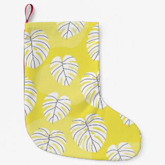 Monstera Blätter, hellgelber Hintergrund. Kleiner Weihnachtsstrumpf