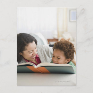 Mutter mit gemischtem Rennen liest Buch an Sohn Postkarte