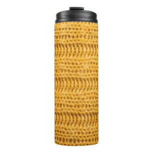 Nah aus gelbem gestricktem Hintergrund. Tr Thermosbecher