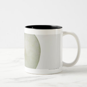 Nahaufnahme eines geschnittenen Oma-Smithapfels Zweifarbige Tasse