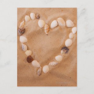 Nahe Herzform aus Muscheln auf Sand Postkarte