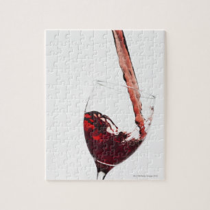 Naher Rotwein, der in Glas auf Puzzle