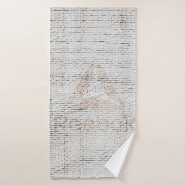 Nahes Foto des Reebok-Logos an der Wand Badehandtuch (Badehandtuch)