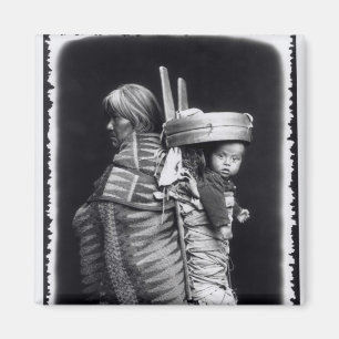 Navajofrau, die ein papoose auf ihr zurückbringt magnet