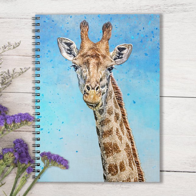 Neugierige Giraffe mit Blue Confetti Sky Notizblock (Sky Blue Notebook with Smiling Giraffe on Tabletop with purple flowers)