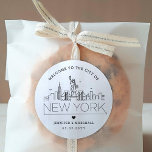 New York Wedding | Begrüßung Runder Aufkleber<br><div class="desc">Erweitern Sie Ihre Hochzeitspakete oder Event-Gastgeschenke mit einem individuellen Set von Begrüßungsaufklebern! Diese eleganten, aber minimalen Aufkleber sind auf eine Hochzeit in der schönen Stadt New York zugeschnitten. Sie verfügen über eine moderne Skyline aus Deko, die den Namen der Stadt trägt und darunter integriert ist. Alle Elemente des Designs, einschließlich...</div>