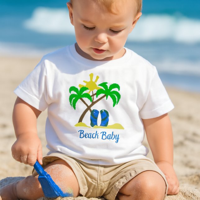 Niedlich Beach Baby T-shirt (a toddler playing in the sand with a small blue shovel, wearing a white crewneck short-sleeve tee-)