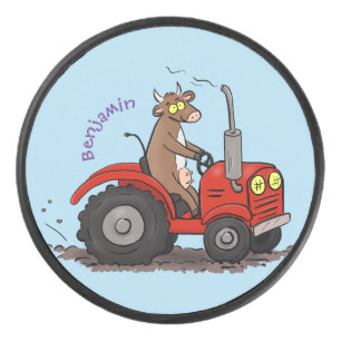 Niedliche glückliche Kuh, die einen roten Traktor- Eishockey Puck