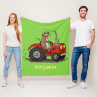 Niedliche glückliche Kuh, die einen roten Traktor-