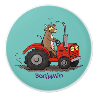 Niedliche glückliche Kuh, die einen roten Traktor- Keramikknauf