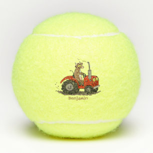 Niedliche glückliche Kuh, die einen roten Traktor- Tennisbälle