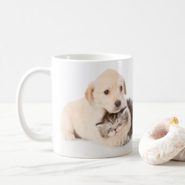 niedliche Katze schläft in den Händen des Hundes Kaffeetasse (Mit Donut)