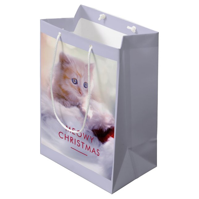 Niedliche Kittenruhe auf einer Weihnachtsmannmütze Mittlere Geschenktüte (Vorderseite Schrägansicht)