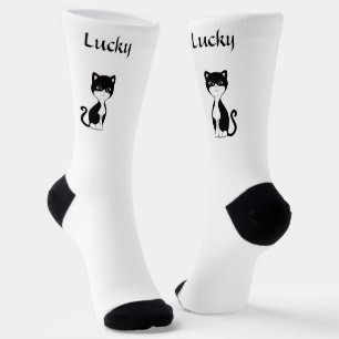 Niedliche Lucky Tuxedo Katze auf weißen Socken