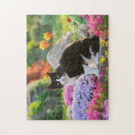 Niedliche Schwarz-weiße Katze in einem blühenden G Puzzle