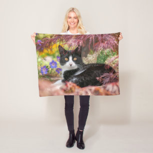 Niedliche schwarz-weiße Katze unter einem Ahornbau Fleecedecke
