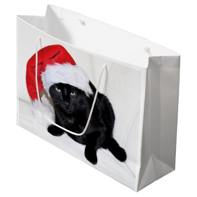 Niedliche schwarze Katze mit Weihnachtsmannmütze Große Geschenktüte (Vorderseite Schrägansicht)
