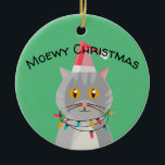 Niedliche Tablettenkatze in Weihnachtsmannmütze Keramik Ornament<br><div class="desc">Adorable Tischkatze in Weihnachtslicht gekleidet mit einer Weihnachtsmannmütze. Ornament liest Meowy Weihnachten.</div>