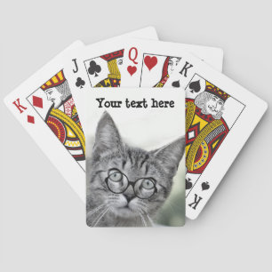 Niedliche und überraschte Katze mit Brille spielt Spielkarten