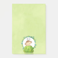 Niedlicher Affe, der von hinter Bush herbeiwindet