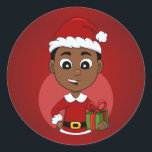 Niedlicher afrikanischer Weihnachtsjunge Cartoon Runder Aufkleber<br><div class="desc">Rundaufkleber mit einer Illustration eines niedlich lächelnden afroamerikanischen Jungen mit kurzem schwarzem Haar trägt der Junge ein Weihnachtskostüm mit einem roten Hut und hält ein Geschenk; in einem roten Kreis auf einem roten Hintergrund ein Weihnachtsferien-Design</div>